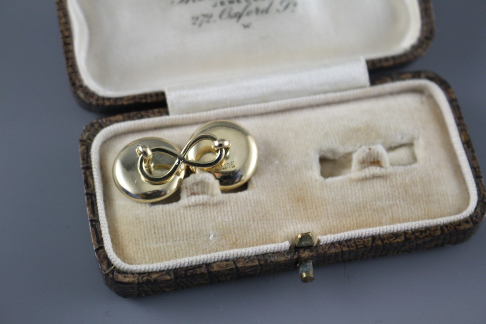 A pair of yellow metal (stamped TM 18ct), mother of pearl and enamel disc cufflinks, gross weight 10 grams, disc 14mm.